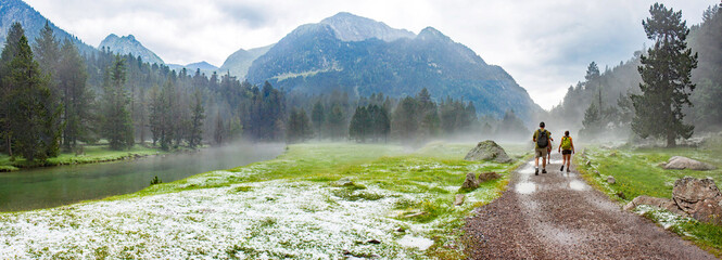 Aigues Tortes National Park, Catalunya, Spain; hikers in, soaked after a sudden hail storm on a...