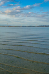 Obraz premium West Wittering, Chichester Harbour, South of England. Small waves gently lap onto the shore in the evening light.
