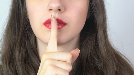Naklejka premium pretty women with her finger on her red lips as symbol for silence