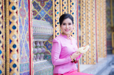 Portrait of a beautiful thai woman wearing a thai dress in a temple, Bangkok, Thailand