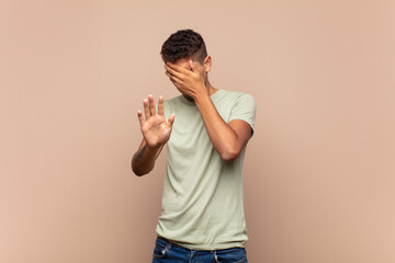  covering face with hand and putting other hand up front to stop camera, refusing photos or pictures