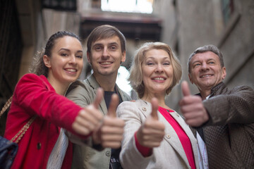 tourists of different generations thumb up and smiling