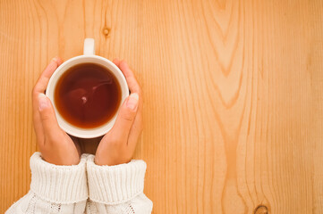woman's hands holding cup of tea 
