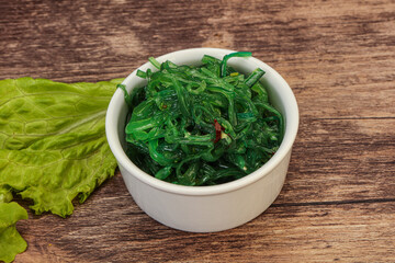 Green Chuka Seaweed Salad Isolated on White Background Top View. Wakame Sea Kelp Salat © Andrei Starostin