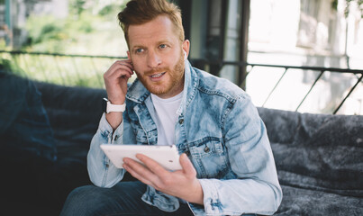 Man sitting on sofa with tablet in city