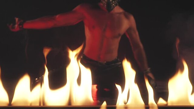 Sexy Man in mask dancing in fire