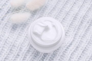 Open jar of cream top view. Grey background. Winter skin care cosmetics concept