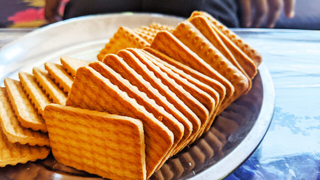 Wheat biscuits in the steel plate with blury background. Indian biscuits popularly known as Chai-biscuit in India