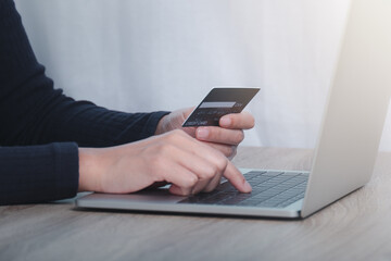 Hand holding credit card and using laptop. Online shopping concept