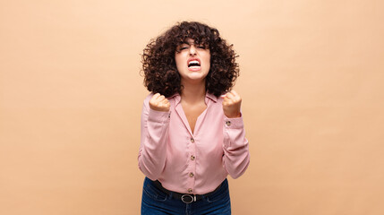  shouting aggressively with annoyed, frustrated, angry look and tight fists, feeling furious