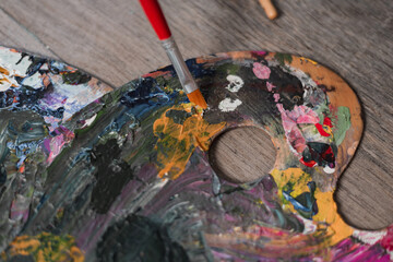 brush close-up on a palette. brush in paint. there are many colors on the palette