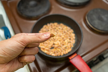 Roasting pumpkin seeds at home. Pumpkin seed in the young man's hand