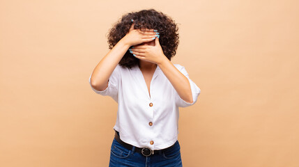  covering face with both hands saying no to the camera! refusing pictures or forbidding photos