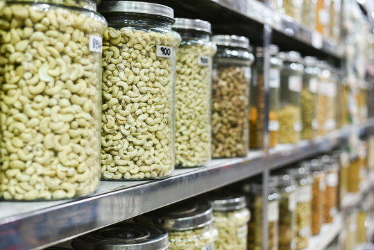 Cashew nuts in glass Jar for sale. Many raw and processed nuts Kerala, India. Whole, salted Anacardium occidentale seeds in spice market for sale