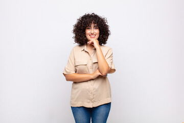  looking happy and smiling with hand on chin, wondering or asking a question, comparing options