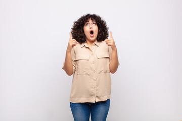  looking shocked, amazed and open mouthed, pointing upwards with both hands to copy space