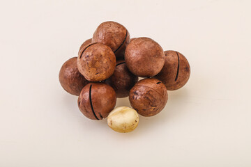Brown macadamia nut heap over background