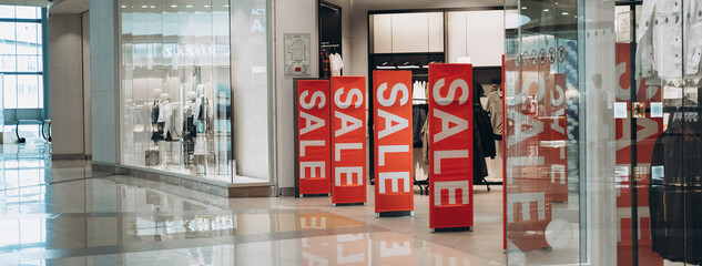 Red banners SALE on anti-thieft gate sensor at clothing store entrance. Black friday sale and...