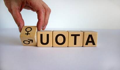 Symbol for womens quota. Hand turns a cube and changes the expression of 'mens quota' to 'womens quota'. Beautiful white background, copy space. Lifestyle concept.