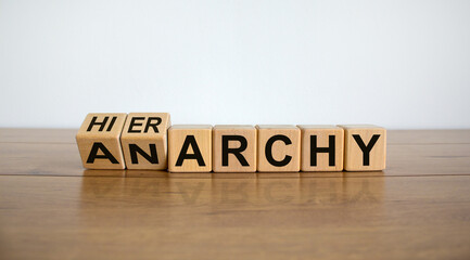 Turned a cube and changed the word 'anarchy' to 'hierarchy'. Beautiful wooden table, white...
