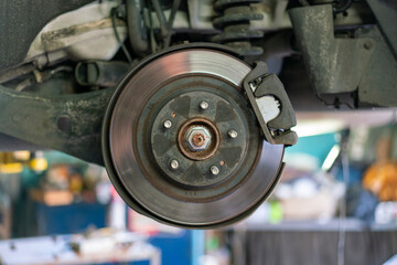 The hub of a wheel in a car service. Suspended car with no wheels. Suspension of car in service...