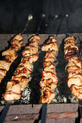 Pork or beef is fried over an open fire. Barbecue kitchen party close-up image. Selective focus. Vertical.