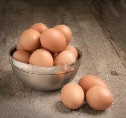 Chicken eggs in cup on wooden table