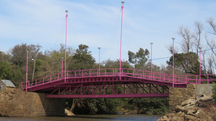 Vista de un puente para automóviles, pintado de color rosa.