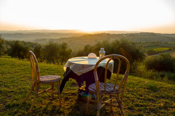Romantic sunset in the area around San Gimignano in Italys Tuscany, with a table and two chairs in the foreground