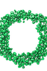 beautiful frame of stones in the form of pebbles painted in green color on a white background. top view, copy space