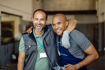 Two happy workers at auto repair shop.