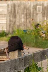 Lost woolly black hat left on wooden post