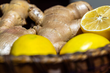 Ginger roots and lemon on wooden basket close up macro shot.
