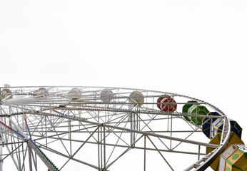 Half of the Ferris wheel against the foggy sky. Entertainment, attractions.