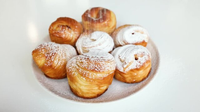 Sprinkling icing sugar on the fresh baked cruffins