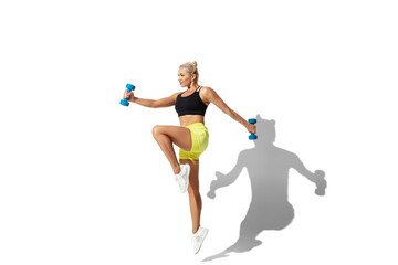 Fototapeta na wymiar Weights. Beautiful young female athlete practicing on white studio background, portrait with shadow. Sportive fit model in motion and action. Body building, healthy lifestyle, style concept.