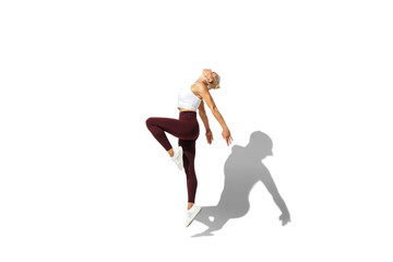 Fototapeta na wymiar Flying like butterfly. Beautiful young female athlete practicing on white studio background, portrait with shadow. Sportive fit model in motion, action. Body building, healthy lifestyle, style concept