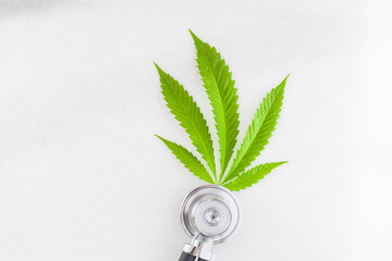 cannabis leaf medical stethoscope on white table. marijuana and health. hemp concept