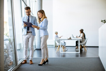 Two business people looking a file in a modern office