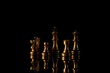 collection of a golden chess figures in the dark.