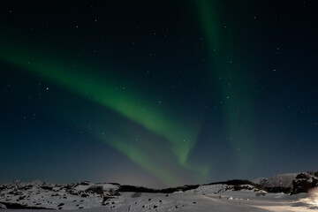 Fototapeta na wymiar Beautiful Northern Lights green above mountain and ocean