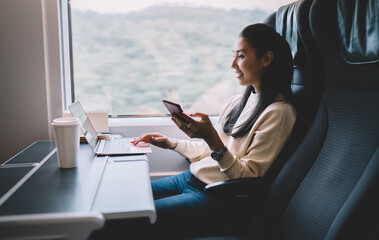 Young woman using smartphone in modern train - Powered by Adobe