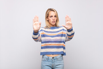  looking serious, unhappy, angry and displeased forbidding entry or saying stop with both open palms
