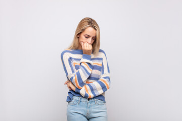  feeling serious, thoughtful and concerned, staring sideways with hand pressed against chin