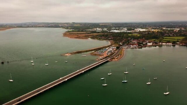 Aerial of road bridge over Langstone Harbour leading to the Marina with yachts in view.