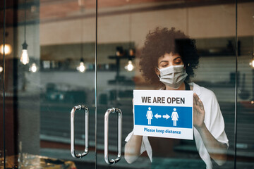 Coffee shop female owner with protective face mask, reopens after lockdown quarantine. Business...