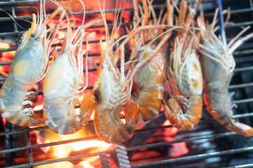 Grilled shrimps on barbecue flaming grill.
