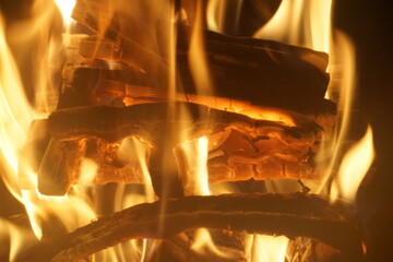 brennendes Feuer und Flammen mit glühenden Holzscheiten in Kamin