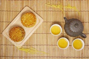 Teapot and moon cake on bamboo table.  Concept for Mid-Autumn Festival or Moon Festival, a traditional holiday in East Asia.