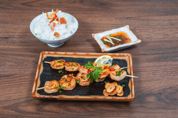 Tasty grilled shrimps with spices and rice served on a plate